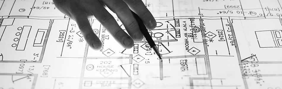 T Level Student in Design, Surveying and Planning for Construction using a pen to draw out blueprint.